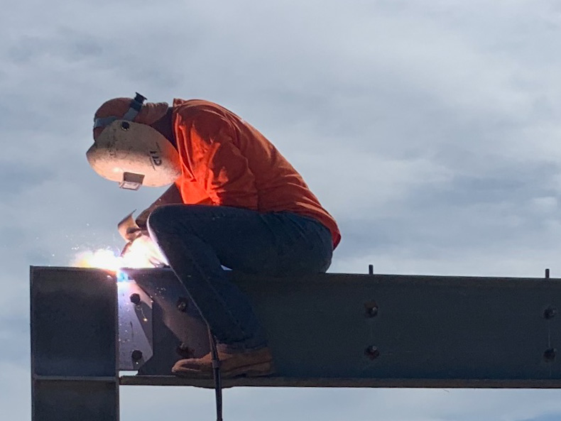 Certified Welding employee performing FCAW on a job site